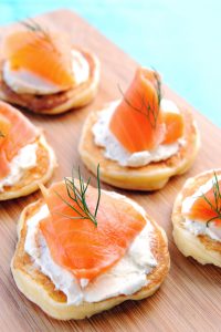 Blini met wilde Alaska zalm en creme voor catering met koude hapjes.
