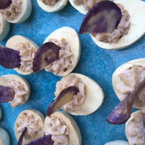 Gevuld half ei met paarse aardappel als garnituur