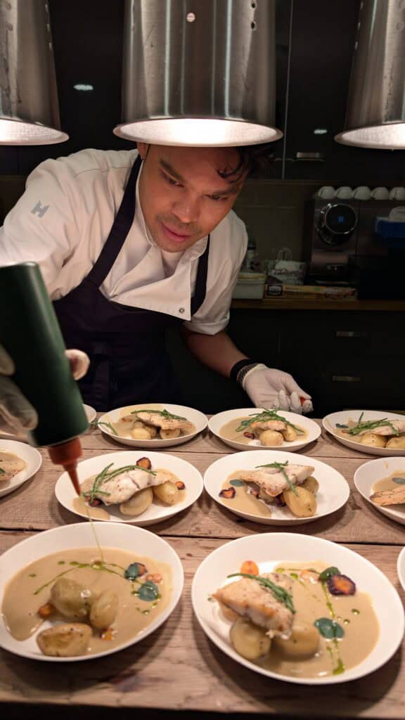 Fine dinning opmaak van borden met met kabeljauw, aardappelen, perterselie saus..