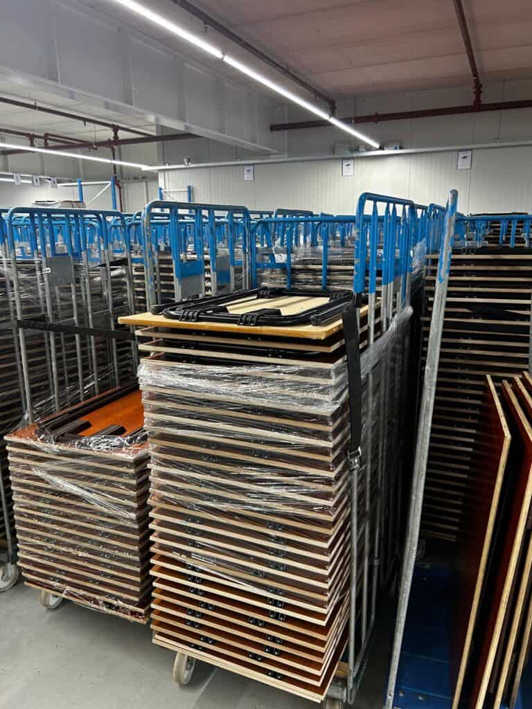 Karren met nieuwe tafels die nog gemonteerd worden