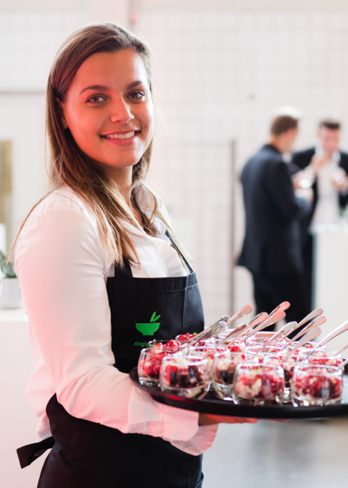vriendelijke bediening met dienblad mini salade op dienblad voor walking lunch catering